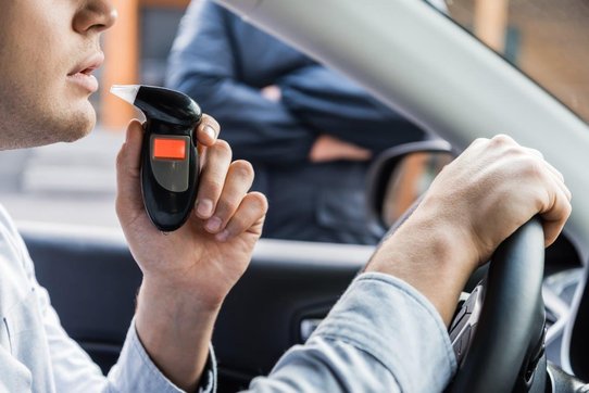 Contrôle_ethylotest_voiture_police Un homme souffle dans un ethylotest au volant de sa voiture